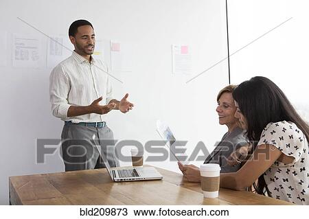 Stock Image - Business people talking in meeting. Fotosearch