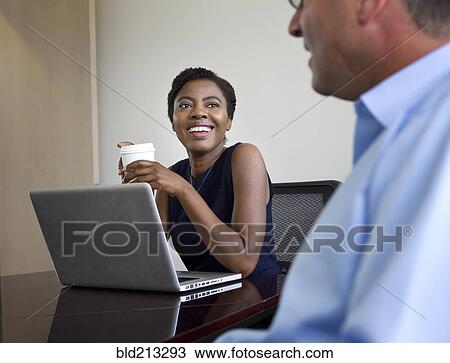 Stock Image - Business people talking in meeting. Fotosearch