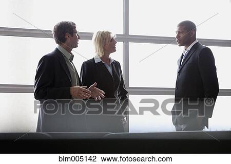 Stock Image - Business people talking in office. Fotosearch