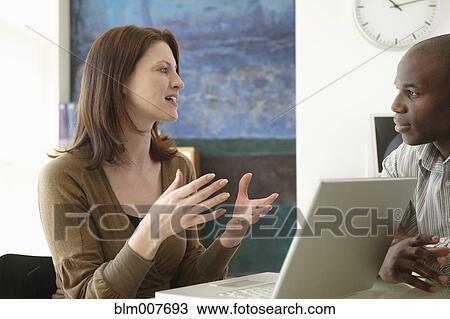 Stock Image - Business people talking in office. Fotosearch