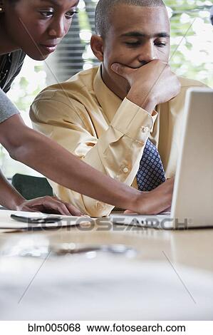 Business people working together on laptop View Large Photo Image Stock Photo - Business people working together on laptop. Fotosearch