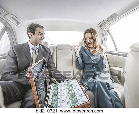 Stock Image - Businessman showing suitcase of money to colleague. Fotosearch