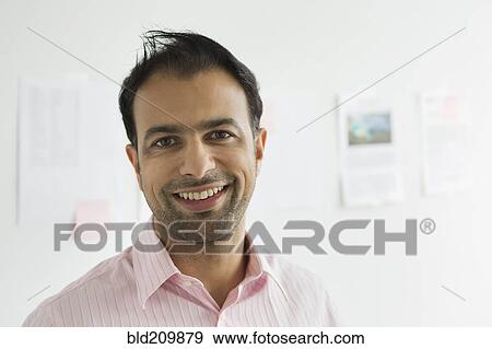 Stock Photo - Businessman smiling in office. Fotosearch