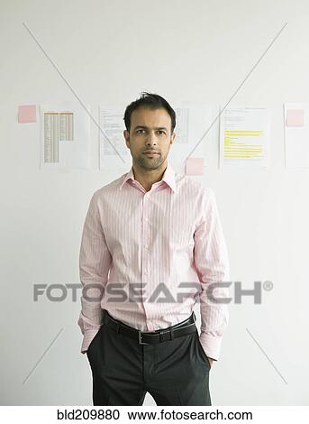 Stock Image - Businessman standing in office. Fotosearch