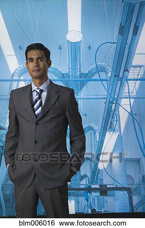 Stock Photograph - Businessman standing with hands in pockets. Fotosearch
