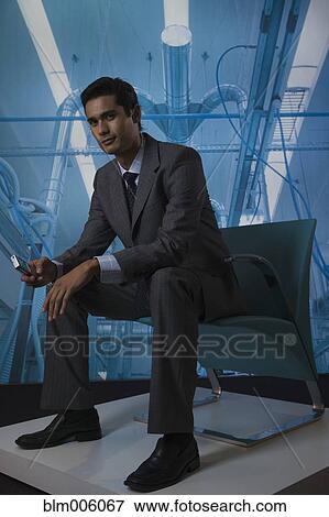 Stock Photo - Businessman text messaging on cell phone. Fotosearch