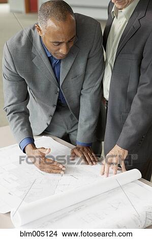 Picture - Businessmen looking at blueprints. Fotosearch