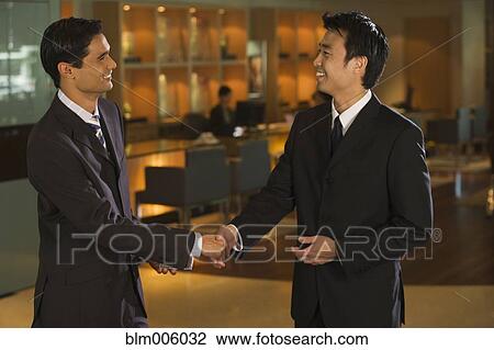 Businessmen shaking hands in bar View Large Photo Image Stock Image - Businessmen shaking hands in bar. Fotosearch