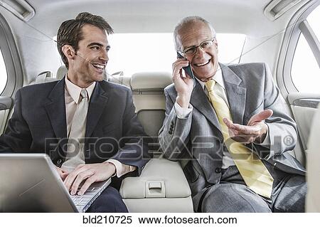 Businessmen working in backseat of car View Large Photo Image Stock Photography - Businessmen working in backseat of car. Fotosearch