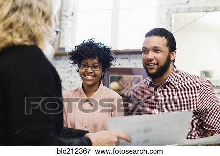 Businesswoman talking to young couple View Large Photo Image Stock Photo - Businesswoman talking to young couple. Fotosearch