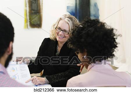 Stock Photograph - Businesswoman talking to young couple. Fotosearch