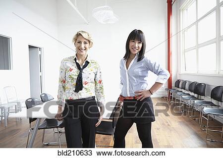 Businesswomen smiling in office View Large Photo Image Stock Image - Businesswomen smiling in office. Fotosearch