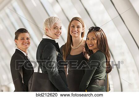 Stock Image - Businesswomen standing in lobby. Fotosearch