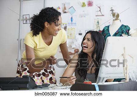 Stock Photo - Businesswomen talking in design studio. Fotosearch