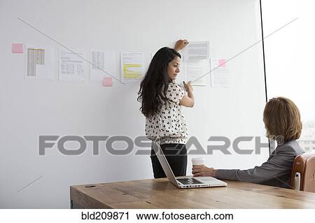 Stock Image - Businesswomen talking in office. Fotosearch