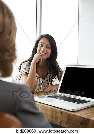 Stock Photo - Businesswomen talking in office. Fotosearch