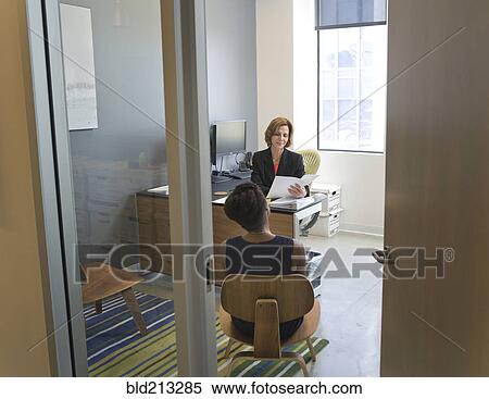 Stock Photography - Businesswomen talking in office. Fotosearch
