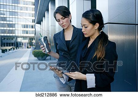Businesswomen using tablet computer in city View Large Photo Image Stock Photograph - Businesswomen using tablet computer in city. Fotosearch