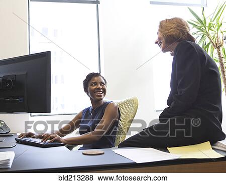 Stock Photo - Businesswomen working together in office. Fotosearch