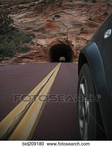 Stock Image - Car driving on rural road in Zion National Park, Utah, United States. Fotosearch