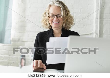 Stock Photo - Caucasian architect working at desk. Fotosearch