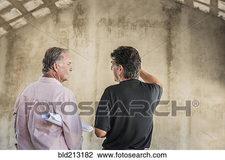 Caucasian architects talking near wall View Large Photo Image Stock Image - Caucasian architects talking near wall. Fotosearch
