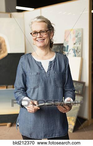 Stock Image - Caucasian artist smiling in studio. Fotosearch