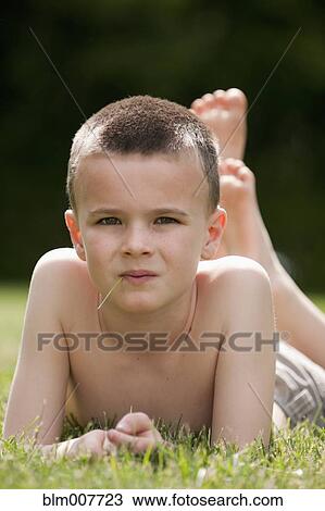 Caucasian boy laying in grass View Large Photo Image Stock Image - Caucasian boy laying in grass. Fotosearch