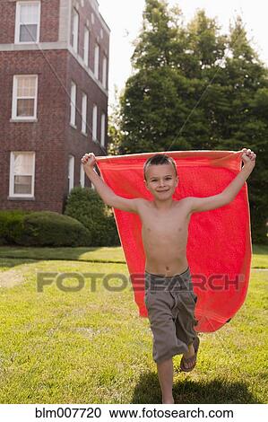 Stock Image - Caucasian boy playing with towel. Fotosearch