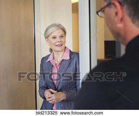 Stock Photography - Caucasian business people talking in office. Fotosearch