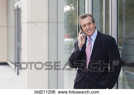 Caucasian businessman on cell phone outside building View Large Photo Image Stock Photograph - Caucasian businessman on cell phone outside building. Fotosearch