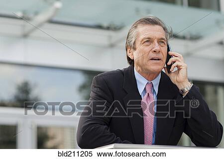 Caucasian businessman on cell phone outside building View Large Photo Image Stock Photography - Caucasian businessman on cell phone outside building. Fotosearch