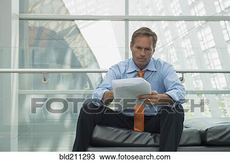 Caucasian businessman reading in lobby area View Large Photo Image Stock Image - Caucasian businessman reading in lobby area. Fotosearch