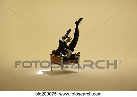 Stock Photography - Caucasian businessman sitting under spotlight. Fotosearch