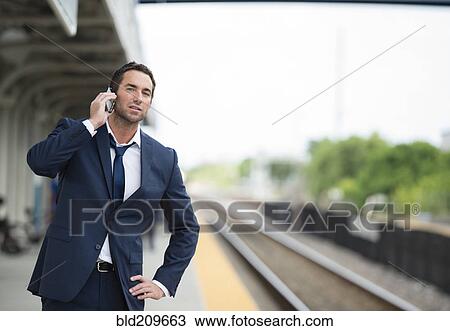 Caucasian businessman talking on cell phone on train platform View Large Photo Image Stock Image - Caucasian businessman talking on cell phone on train platform. Fotosearch