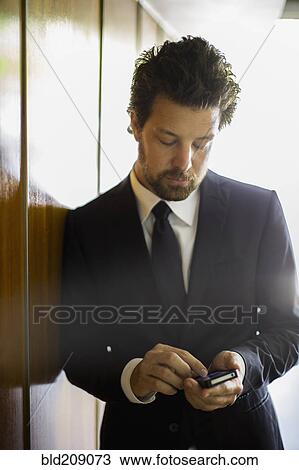 Stock Image - Caucasian businessman using cell phone. Fotosearch