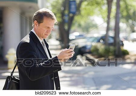 Stock Image - Caucasian businessman using cell phone. Fotosearch