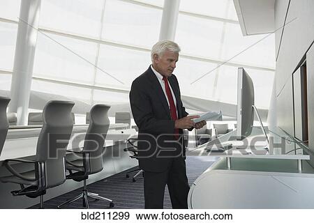Stock Photo - Caucasian businessman using computer in conference room. Fotosearch