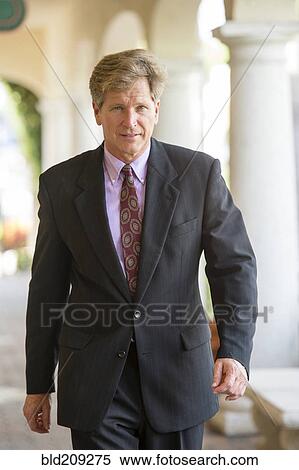 Caucasian businessman walking in colonnade View Large Photo Image Stock Photography - Caucasian businessman walking in colonnade. Fotosearch