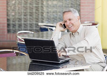 Stock Photography - Caucasian businessman working at cafe. Fotosearch