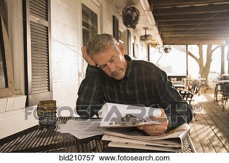 Stock Photo - Caucasian businessman working on patio. Fotosearch