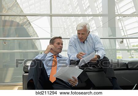 Caucasian businessmen talking in lobby area View Large Photo Image Picture - Caucasian businessmen talking in lobby area. Fotosearch