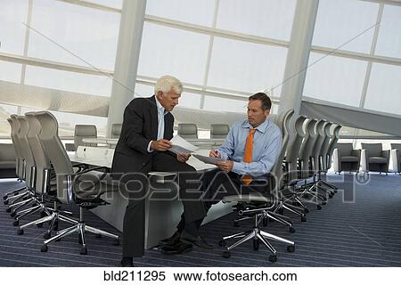 Stock Photography - Caucasian businessmen talking in conference room. Fotosearch