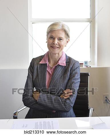 Stock Image - Caucasian businesswoman smiling in office. Fotosearch