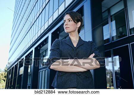 Picture - Caucasian businesswoman standing with arms crossed outdoors. Fotosearch