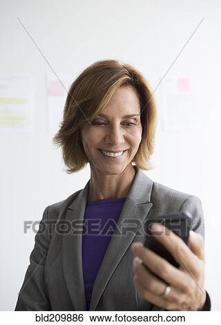 Caucasian businesswoman using cell phone in office View Large Photo Image Stock Photograph - Caucasian businesswoman using cell phone in office. Fotosearch