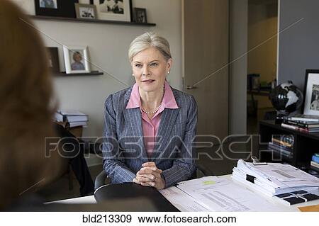Stock Photo - Caucasian businesswomen talking in office. Fotosearch
