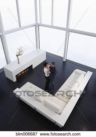 Stock Photo - Caucasian couple dancing in modern living room. Fotosearch