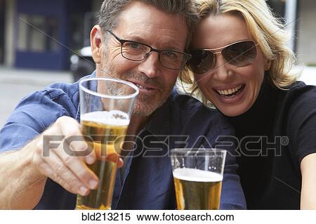 Stock Photography - Caucasian couple drinking beer outdoors. Fotosearch