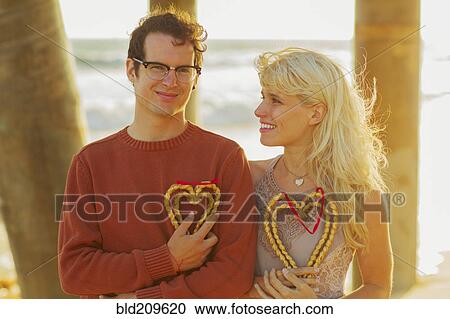 Stock Image - Caucasian couple holding woven hearts. Fotosearch